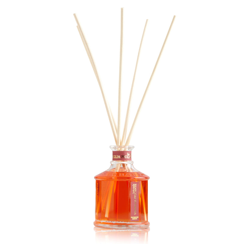  Glass bottle with light red color spicy vanilla home fragrance liquid and reed sticks.