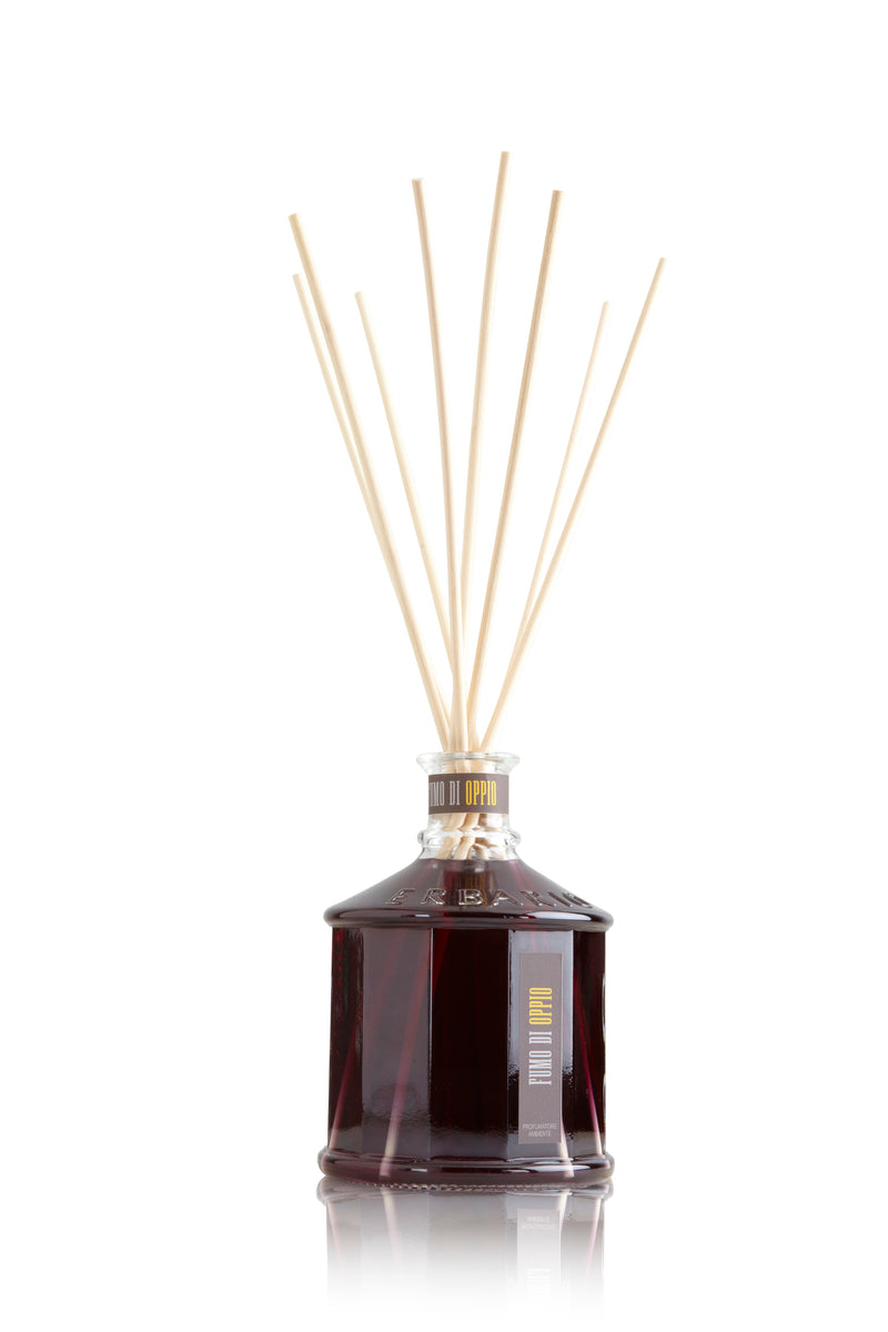 Glass bottle with purple color opium smoke home fragrance liquid and reed sticks.