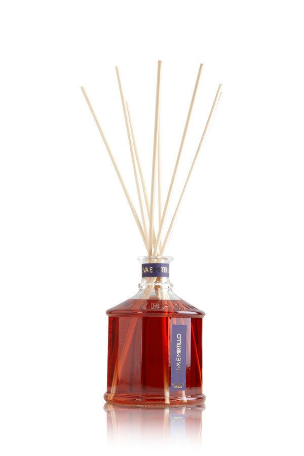 Glass bottle with red color grape & blueberry home fragrance liquid and reed sticks.